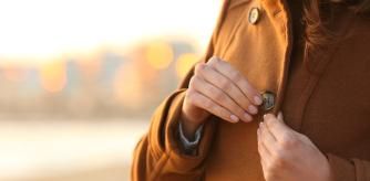 Una mujer abrochándose la chaqueta.