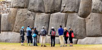 Turistas ante uno de los muros de la fortaleza de Sacsayhuamán, en Cuzco, Perú.