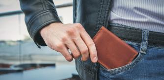 Un hombre sacándose la cartera del bolsillo.