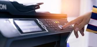 Una persona usando una impresora multifunción.