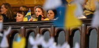 Young attendees are pictured through some 528 paper angels, said to represent the number of children killed in Ukraine sice the beginning of the invasion by Russia, during an Inter-faith Prayer Service for peace in Ukraine, at the Ukrainian Catholic Cathedral in London, on February 24, 2024, during a service to mark 2 years since the beginning of the invasion. (Photo by Ben Stansall / AFP)