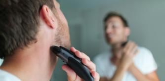 Un hombre afeitándose con una maquinilla de afeitar.