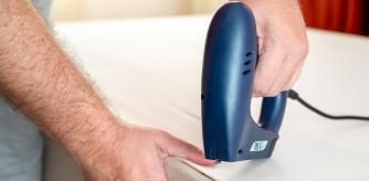 Una persona usando una grapadora eléctrica.