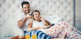 Pareja en pijama disfrutando de su desayuno.