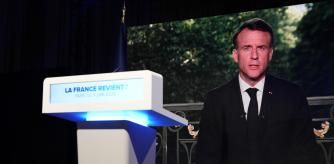 French President Emmanuel Macron appears on television screen at the French far-right National Rally party election night headquarters, Sunday, June 9, 2024 in Paris. French President Emanuel Macron dissolves National Assembly and calls new legislative election after defeat in EU vote (AP Photo/Lewis Joly)