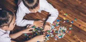 Niños jugando con un puzzle en casa.