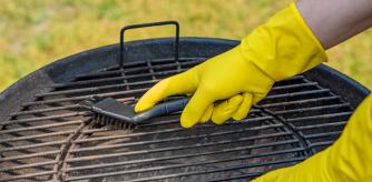 Una persona limpiando la barbacoa de carbón