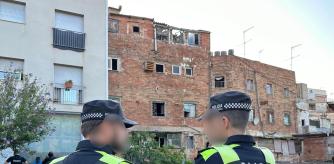 Dos agentes de la Guàrdia Urbana de Badalona frente a los dos edificios desocupados en el barrio de la Morera de Badalona (Barcelona)