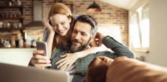 Una pareja en casa mirando el móvil