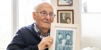 (FILES) The 99-year-old Holocaust survivor Albrecht Weinberg poses with a photo of (L-R) him, his brother Diedrich and his sister Friedel at his home in Leer (East Frisia), Germany, on December 30, 2024. Albrecht Weinberg survived the concentration camps of Auschwitz, Dora-Mittelbau and Bergen-Belsen, emigrated to the USA and returned to his homeland of East Frisia after decades as a shopkeeper in New York. (Photo by FOCKE STRANGMANN / AFP)