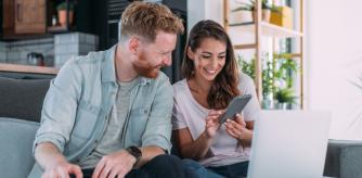 Una pareja mira alegremente ofertas de Amazon por ordenador