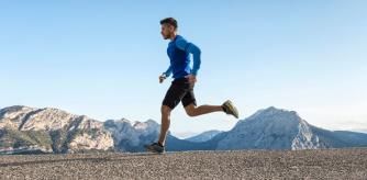 Un hombre corre por la montaña a pleno sol