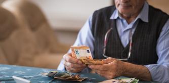 Una persona mayor contando billetes de euro