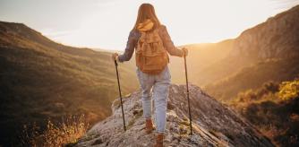 Una mujer practica trekking por la montaña a primera hora de la mañana