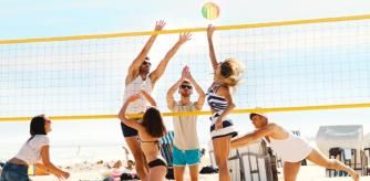 Un grupo de amigos se divierte jugando al fútbol en la playa