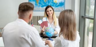 Una pareja recoge sus billetes para viajar en una agencia