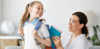 Una madre coloca los libros de texto en la mochila de su hija