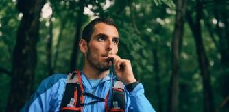 Un deportista bebe agua de su CamelBak antes de proseguir con la ruta