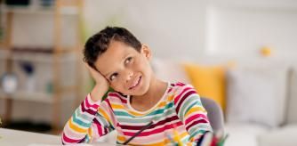 Un niño piensa una respuesta mientras repasa con un cuaderno de refuerzo