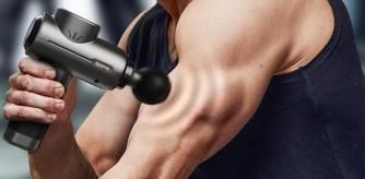 Un deportista utilizando la pistola para darse un masaje en los brazos