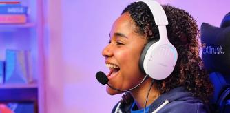 Una chica jugandoc on su PC y lleva puestos los auriculares