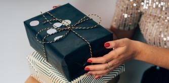 Una mujer con varias cajas de regalos en la mano