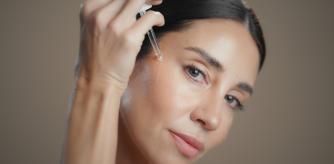 Una mujer poniéndose sérum en el rostro