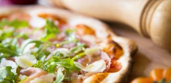 Pizza de jamón de Parma, rúcula, tomate confitado y Parmesano