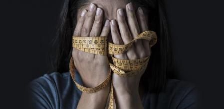 Una mujer con trastornos alimenticios obsessed with diet and overweight