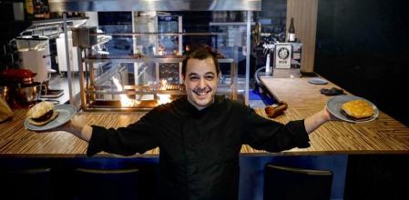 Jordi Bernús con dos de los bocadillos de carne que prepara en Sants es Crema