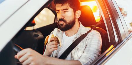 Un conductor come un plátano mientras está al volante