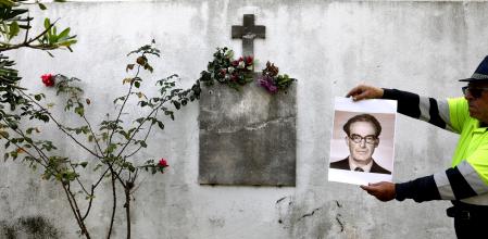 Un operario sostiene una foto de Bertrán ante una pared del cementerio de Montcada donde se enterreraron muchas víctimas de la represión