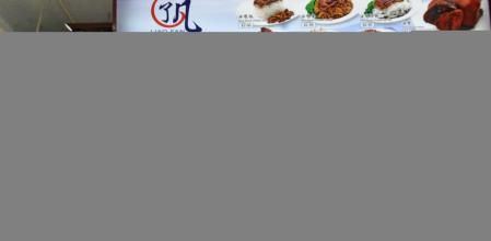 Singaporean chef Chan Hon Meng (front L) poses infront of his Hong Kong Soya Sauce Chicken Rice and Noodle stall in Singapore on July 22, 2016. - Culinary bible Michelin on July 21 awarded one star each to two street food hawkers in Singapore, the first in the guide's history. Launching the inaugural restaurant and hotel guide to the Southeast Asian city-state, Michelin inspectors gave one star each to Hill Street Tai Hwa Pork Noodle and Hong Kong Soya Sauce Chicken Rice & Noodle. (Photo by ROSLAN RAHMAN / AFP)