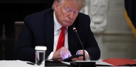 FILE - In this Thursday, June 18, 2020 file photo, President Donald Trump looks at his phone during a roundtable with governors on the reopening of America's small businesses, in the State Dining Room of the White House  in Washington. Though stripped of his Twitter account for inciting rebellion, President Donald Trump does have alternative options of much smaller reach. (AP Photo/Alex Brandon, File)