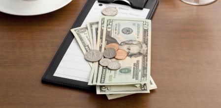 Billetes y monedas sobre la cuenta de un restaurante