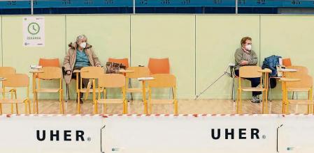 Elderly residents sit and wait after receiving Moderna COVID-19 vaccine at a sports hall in Ricany, Czech Republic, Friday, Feb. 26, 2021. With new infections soaring due to a highly contagious coronavirus variant and hospitals filling up, one of the hardest-hit countries in the European Union is facing inevitable: a tighter lockdown. (AP Photo/Petr David Josek)
