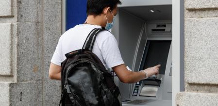 Una persona saca dinero de un cajero
