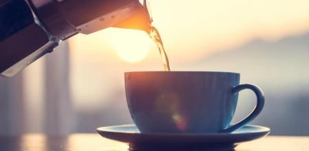 Una persona se sirve café mientras amanece