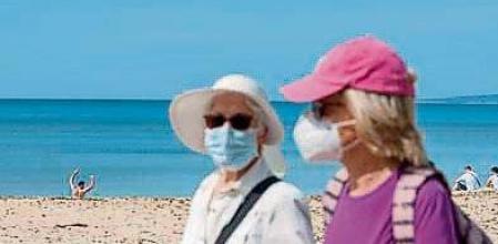 GRAF5049. PALMA DE MALLORCA, 31/03/2021.- Turistas caminan por el paseo marítimo de la playa de Palma de Mallorca, este miércoles, cuando entra en vigor la obligación de llevar mascarilla aún con distancia de seguridad. La consellera de Salud y Consumo de Baleares, Patricia Gómez, ha informado de que el Govern interpreta que la mascarilla no es obligatoria en playas y espacios naturales para quienes van solos o con sus convivientes y mantienen la distancia respecto a los demás, pero sí en las reuniones sociales en esos lugares, al margen de lo que diga la ley estatal aprobada el martes. EFE/ Atienza