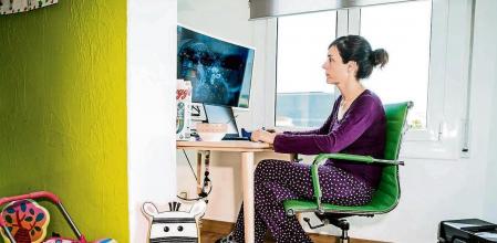 foto XAVIER CERVERA 12/04/2021 tras muchos meses d pandemia por coronavirus el reencuentro -tras el teletrabajo- en la oficina sera mas presente, aunque todavia hay trabajadores y trabajadoras q prefieren evitar riesgos (esperando a estar vacunados /as) y seguir teletrabajando, solos o solas (aislados fisicamente pero conectados digitalmente) en casa, compartiendo espacio en el salon con elementos infantiles d hijos hijas (dibujos, sillitas, juguetes,..) ; lo unico q les queda en el espacio laboral de la oficina es la tipica foto de familia con la pareja, y las hermanas hijas (como es el caso d esta mujer biologa)