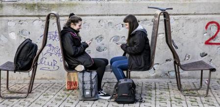 Dos jóvenes utilizando sus teléfonos móvil