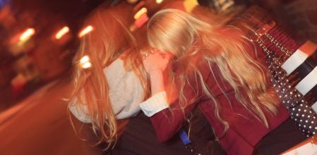 Dos chicas caminan de noche por la calle