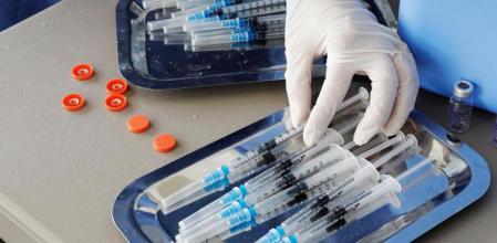 enfermera prepara inyectores para poner dosis de la vacuna contra la covid-19 hoy, en el Mallplaza, uno de los centros comerciales habilitados como punto de vacunación masiva, en Bogotá (Colombia).