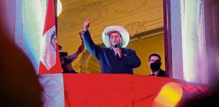 Peru's left-wing presidential candidate Pedro Castillo of the Peru Libre party, gestures as he speaks to his supporters from the balcony of his party headquarters in Lima on June 10, 2021. - Final results from Peru's presidential election -- in which leftist Pedro Castillo considers himself the winner -- are still days away, officials said Thursday, as a prosecutor sought preventive custody for corruption-accused candidate Keiko Fujimori. (Photo by Gian MASKO / AFP)