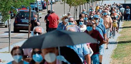 VALLADOLID, 16/07/2021.- Un grupo de personas esperan su turno para vacunarse hoy en el Centro Cultural Miguel Delibes de Valladolid este viernes, día en el que la quinta ola del coronavirus sigue disparada en Castilla y León donde este viernes se han notificado 1.796 nuevos casos, que son 41 menos que este pasado jueves, mientras que se han producido dos muertes más y los brotes activos ascienden a 530, que son 45 más que ayer. EFE/Nacho Gallego