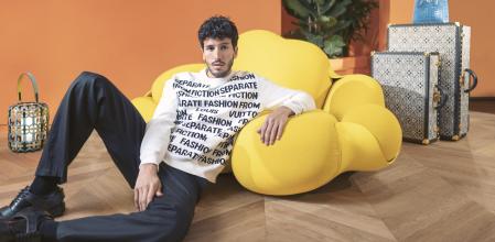 Total look de la Maison, está apoyado sobre Silla Concertina de Raw Edges junto a un juego de baúl, maleta Alzer y sombrera de la colección ‘Since 1854’, todo de Louis Vuitton