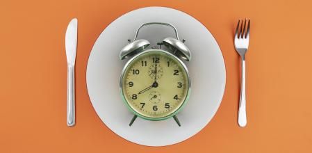 Reloj despertador encima de un plato