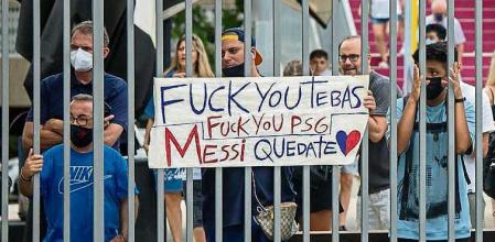 AFICIONADOS DEL FC BARCELONA CON ALGUNA PANCARTA EN LAS PUERTAS DEL ESTADIO CAMP NOU TRAS LA NOTICIA DE LA SALIDA DEL JUGADOR LEO MESSI DEL CLUB