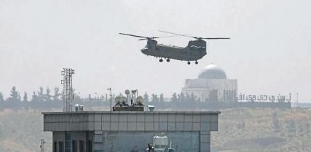 A U.S. Chinook helicopter flies over the U.S. Embassy in Kabul, Afghanistan, Sunday, Aug. 15, 2021. Helicopters are landing at the U.S. Embassy in Kabul as diplomatic vehicles leave the compound amid the Taliban advanced on the Afghan capital. (AP Photo/Rahmat Gul)