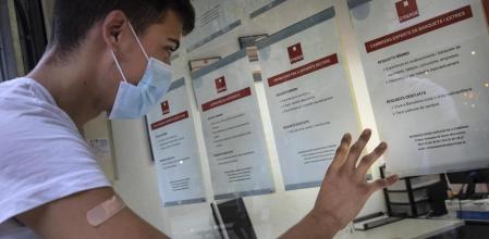 Joven vacunado consulta ofertas de trabajo en una ETT de Barcelona